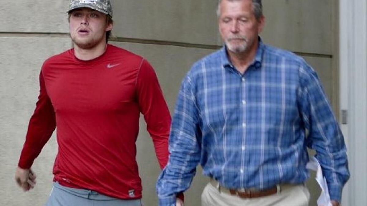 Kevin Olsen leaves the Mecklenburg County Jail on Feb. 20 with his father, Chris. The suspended UNCC quarterback, accused of rape, face two court hearings in the coming week