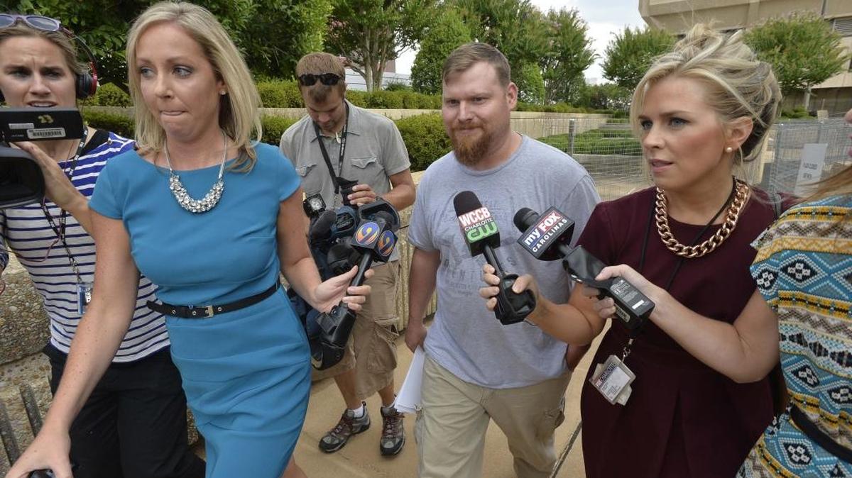 Surrounded by reporters, Sandy Parsons leaves the federal courthouse in Winston-Salem in 2014 after he and his wife Casey Parsons were arrested on fraud charges.