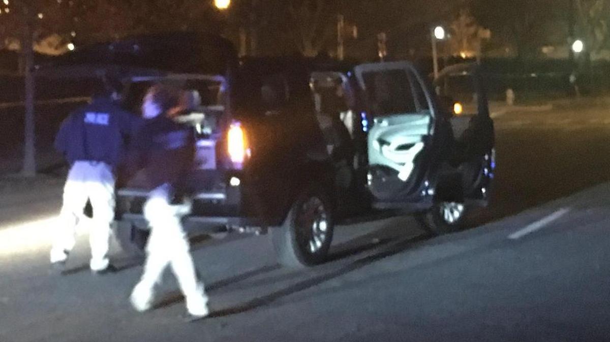 Police inspect one of the vehicles involved in a Feb. 25 shootout on Caldwell Street in uptown Charlotte.