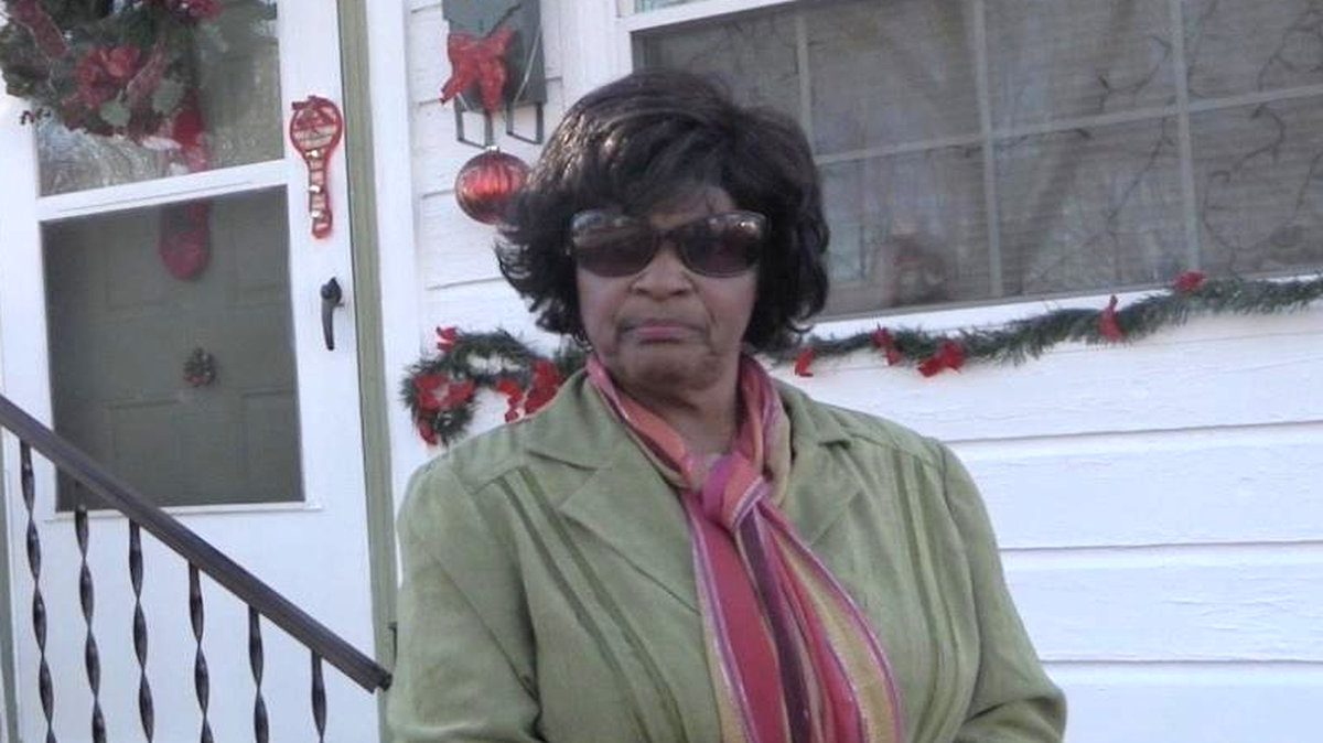 Marguerite Moore in front of her Harrison Street home.