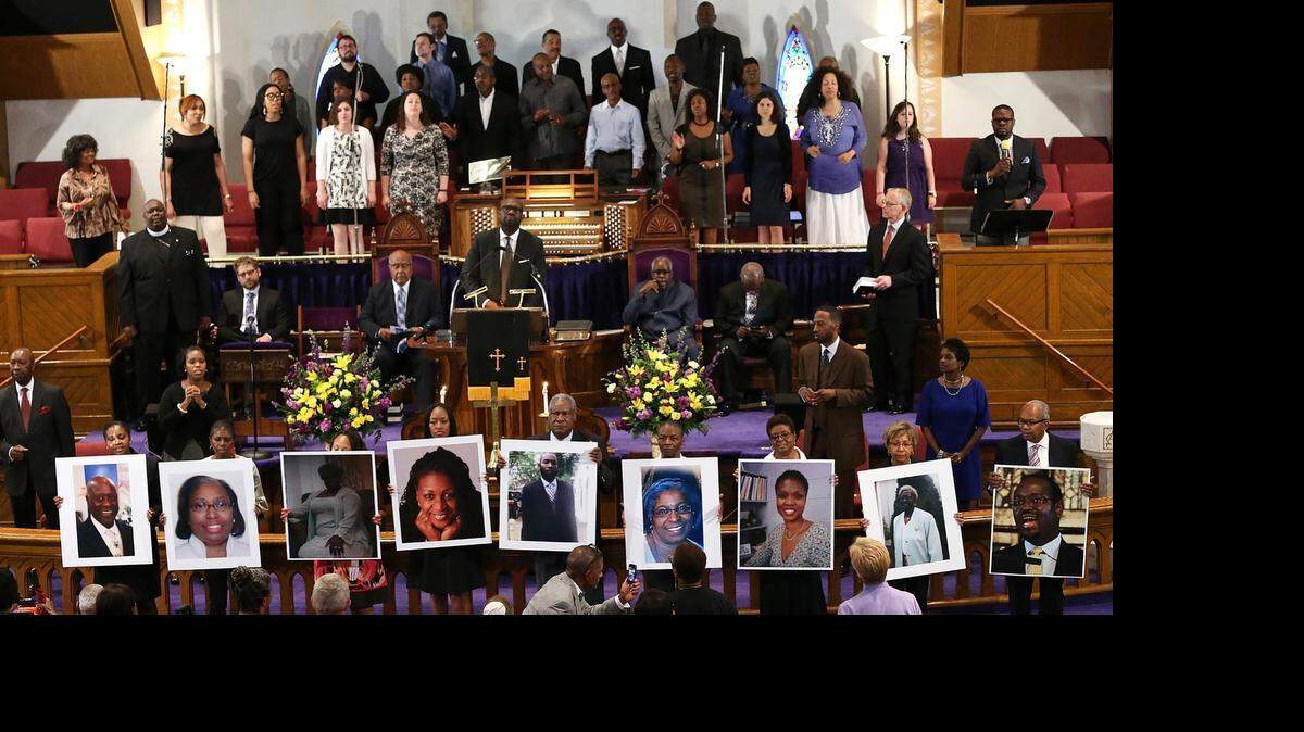 
WASHINGTON, DC - JUNE 19: Photographs of the nine victims killed at the Emanuel African Methodist Episcopal Church in Charleston, South Carolina are held up by congregants during a prayer vigil at the the Metropolitan AME Church June 19, 2015 in Washington, DC. Earlier today the suspect in the case, Dylan Storm Roof, was charged with nine counts of murder. (Photo by Win McNamee/Getty Images) 

