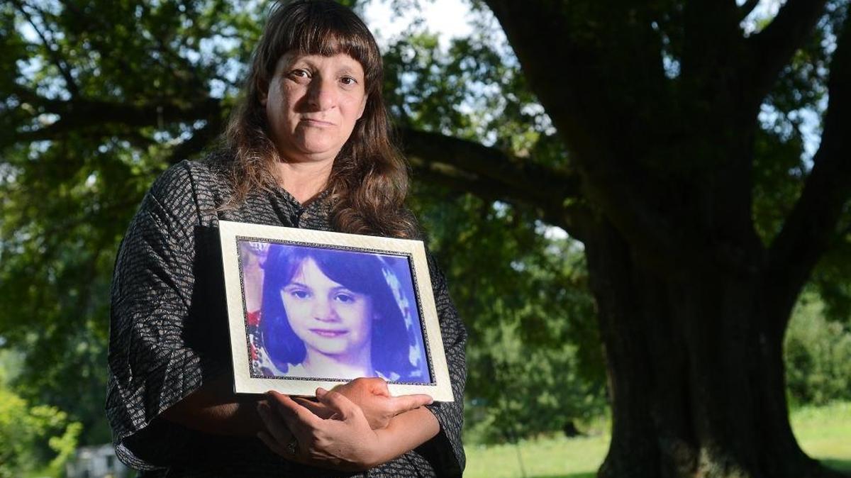 Carolyn Parsons, biological mother of Erica Parsons, holds up a picture of her missing daughter in 2014 to bring attention to the national search that was launched. Erica was a home-schooled, developmentally disabled and isolated.