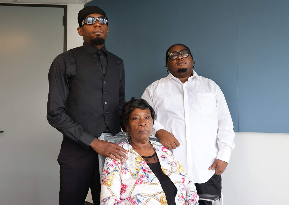 Demetrics McGill, center, sits with her sons, DeMontrez Mobley and Cordario McGill. Her other son, Sanrico McGill, was shot and killed by police in 2023.