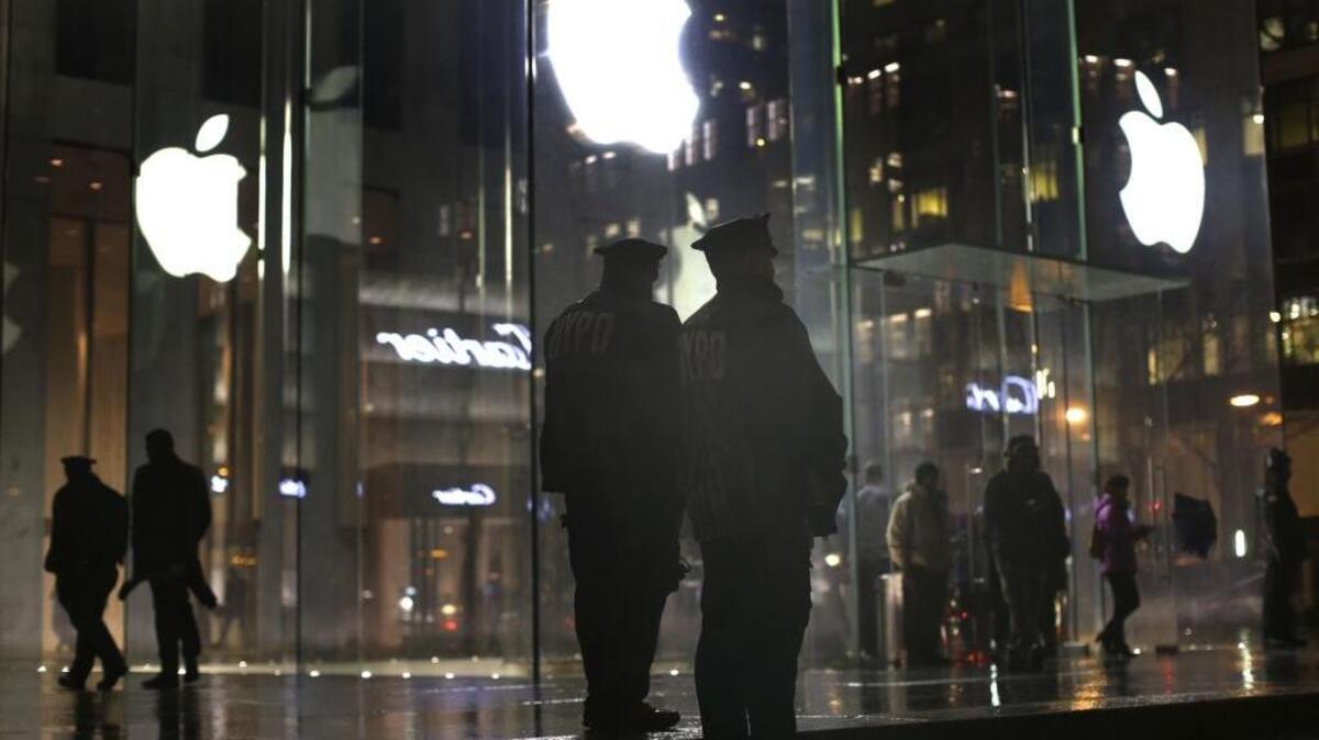 Police officers stand guard last week during a demonstration outside the Apple Store in New York City. Protesters assembled in more than 30 cities around the world to lash out at the FBI for obtaining a court order that requires Apple to make it easier to unlock an encrypted iPhone.