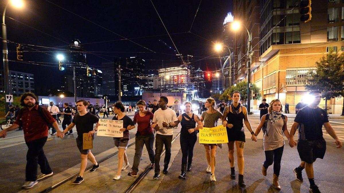 Charlotte protesters hold hands as they march on Saturday night -- the fifth straight night of protests following the fatal police shooting of Keith Lamont Scott.