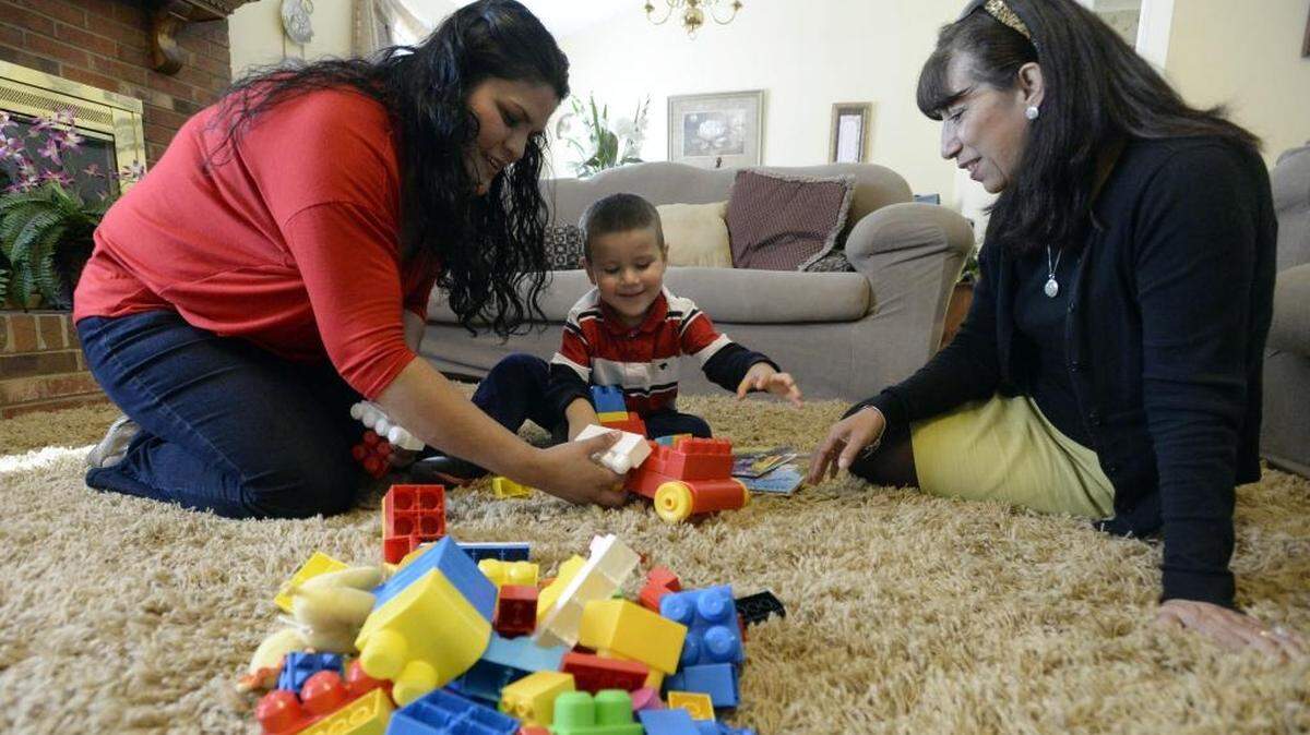 Olga Castaneda, left, plays with son Mateo Policarpo, 3, as Elizabeth Borja with Parents As Teachers observes at the family's home on Wednesday, October 21, 2015. The program is sponsored by the YMCA of Greater Charlotte and is aimed at helping immigrant families who don't speak English well become better at preparing their kids for school.