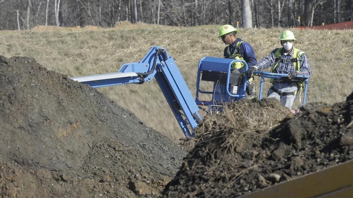 Workers excavate coal ash-laden soil from Duke Energy’s Dan River power plant in Eden.
