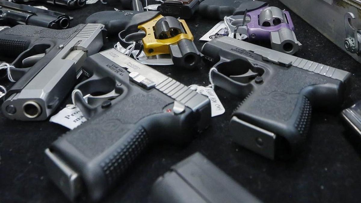 In this file photo, handguns are displayed on a vendor’s table at a gun show in Albany, N.Y.