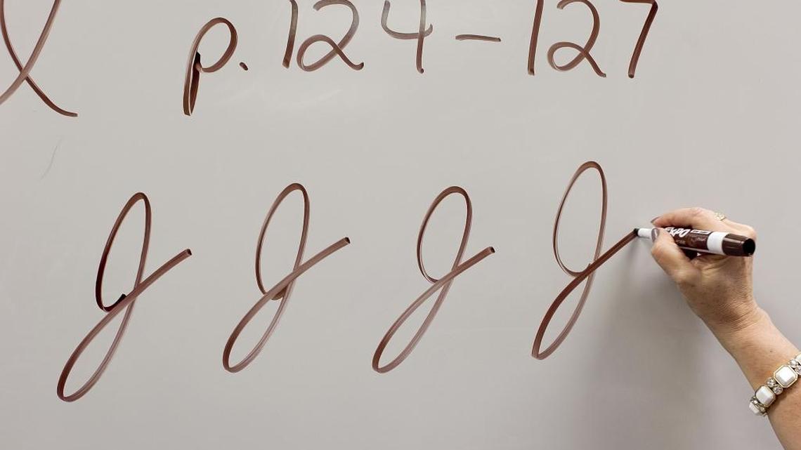 A teacher demonstrates the cursive J in her third grade class in a file photo.