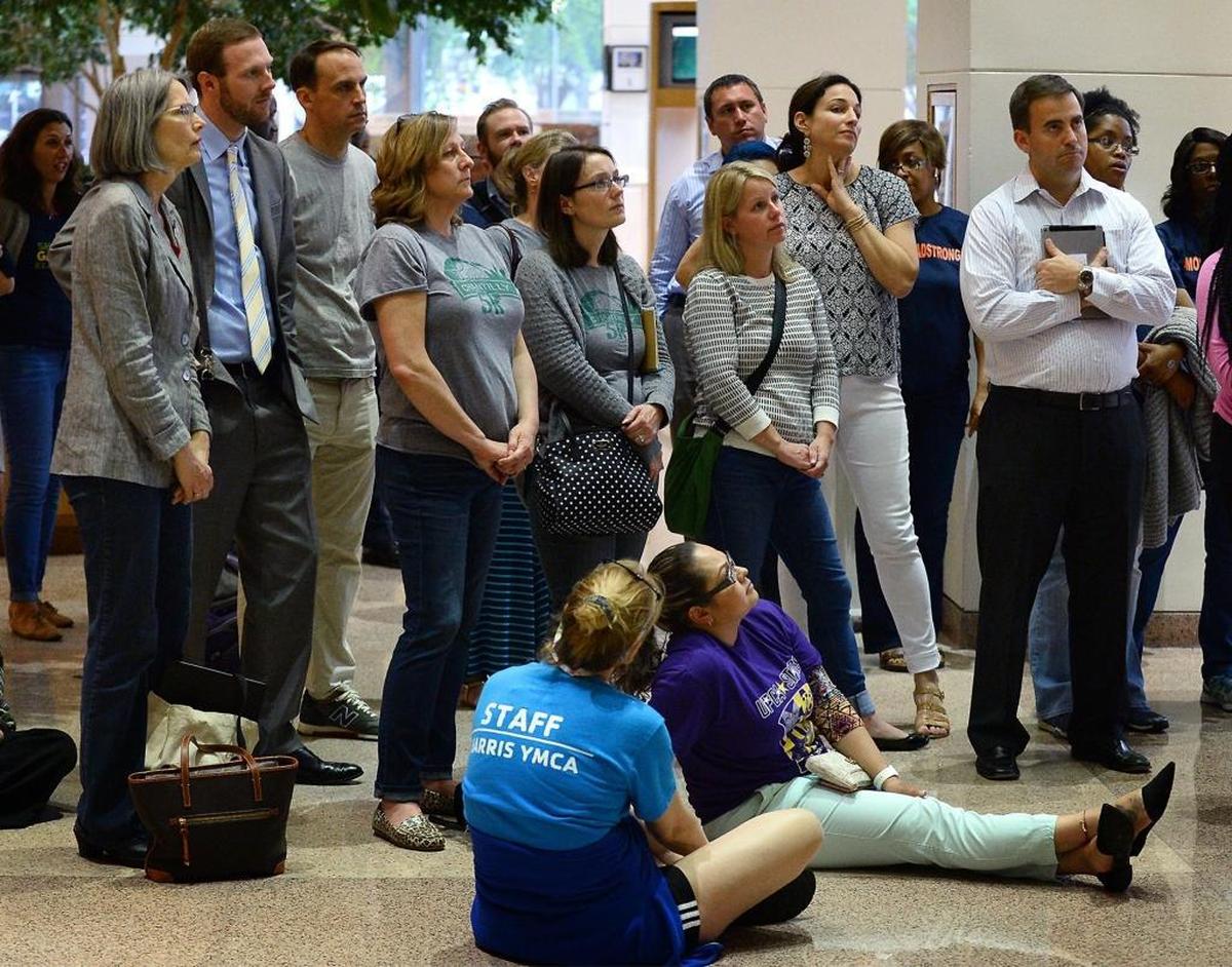 An overflow crowd gathers around one of the TV monitors in the lobby of the Charlotte Mecklenburg County Government Center on Tuesday evening.