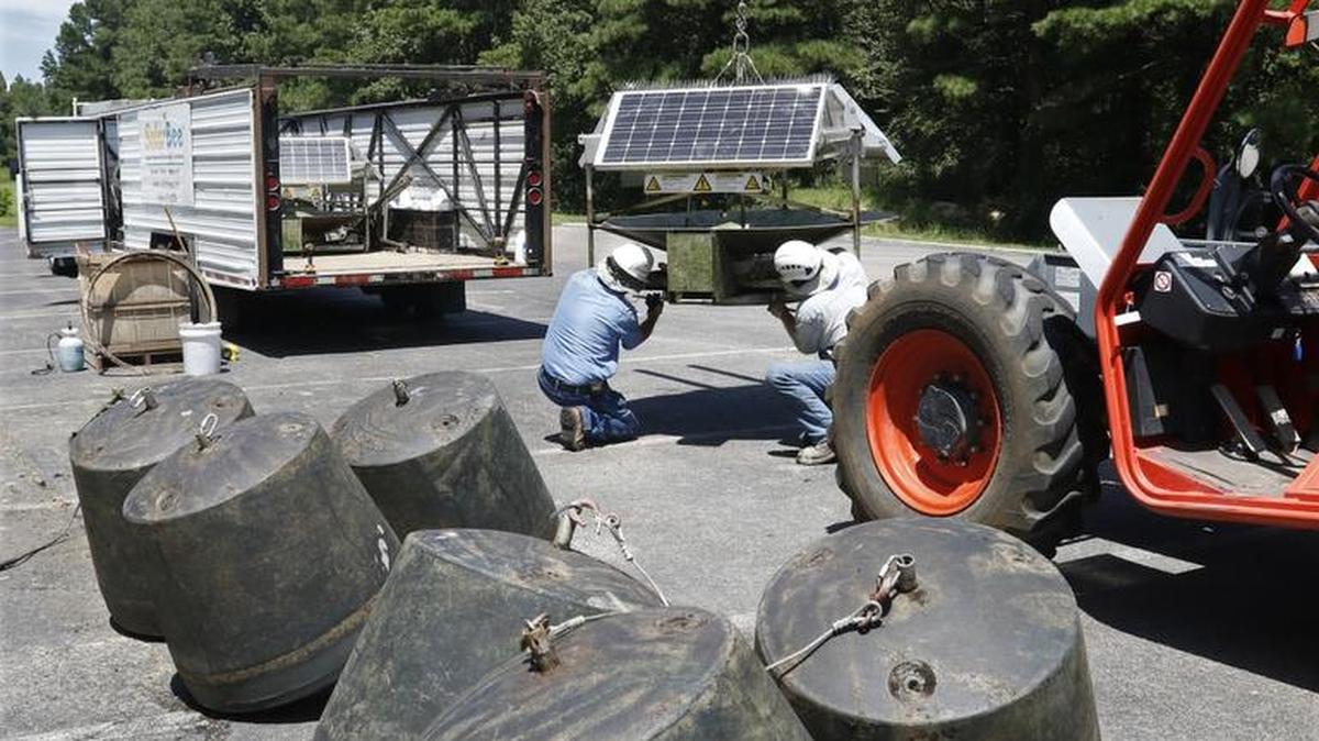 SolarBee floating anchors, foreground, await loading as SolarBee employees Steve Shanabarger, left, and Cody Lague disassemble a SolarBee core unit August 11, 2016 at Farrington Point boat ramp at Jordan Lake in Chatham County. Twenty four of the SolarBee reservoir circulators were installed in the northern part of Jordan Lake in hope of reducing algae blooms in July 2014 but were found by the NC Department of Environmental Quality to be ineffective. The units in the northern part of Jordan Lake were being collected and disassembled for removal back to North Dakota this week. Shanabarger said that the remaining 12 SolarBee units in the Haw River at Robeson Creek landing will be removed next week.