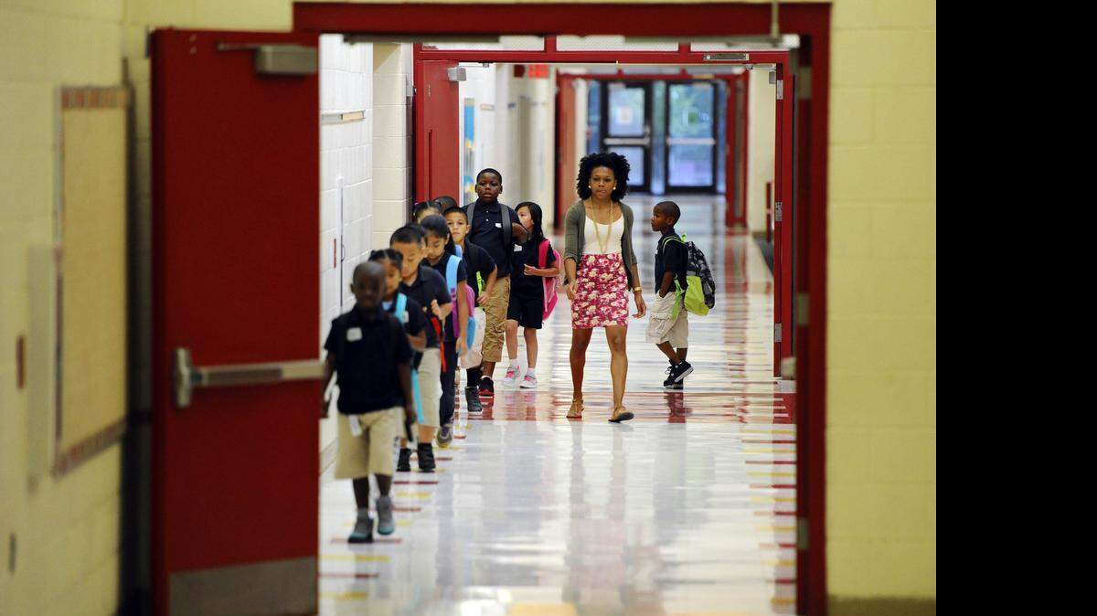 
Second grade math teacher Mone Carthen helps her students practice walking in the hallway of Thomasboro Academy, a year-round Project LIFT school during the first day of school on Monday, July 20, 2015.
