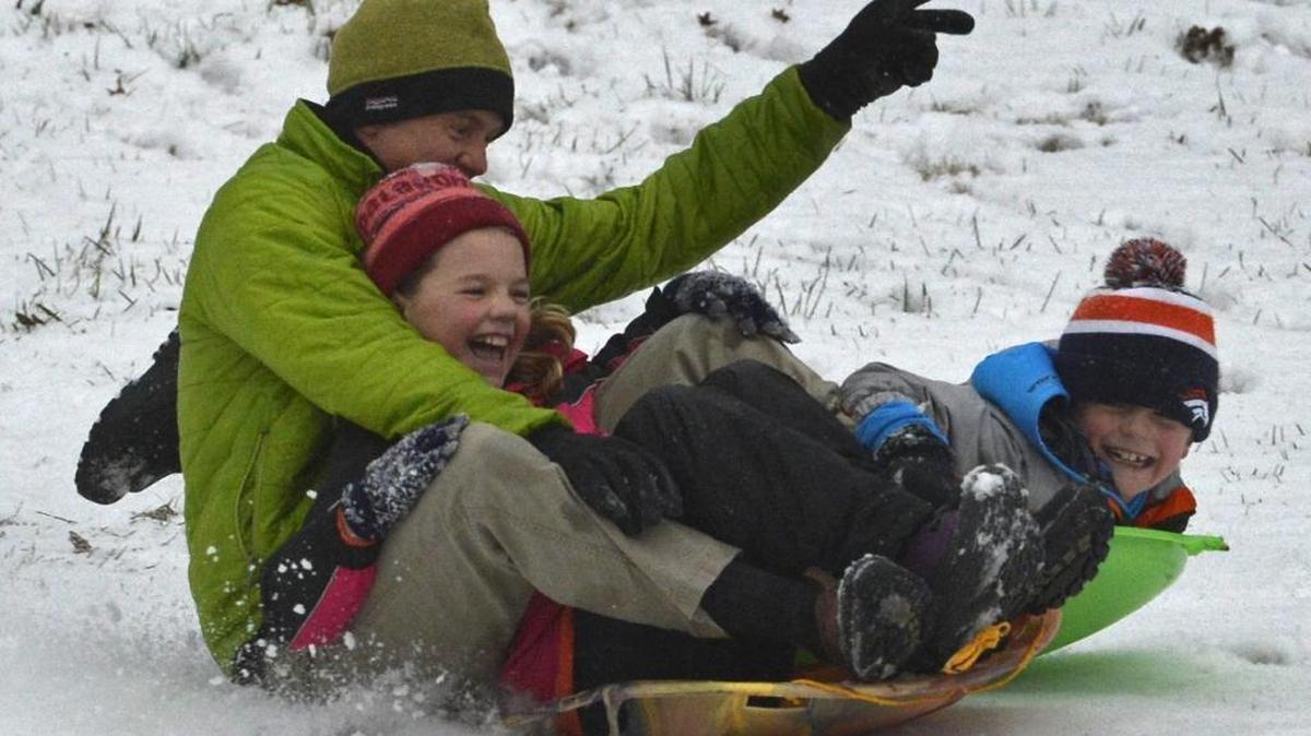 Lou Waple enjoys the snow with kids Emma, 10, and Nelson, 8, at Latta Park, Friday morning, January 22, 2016.