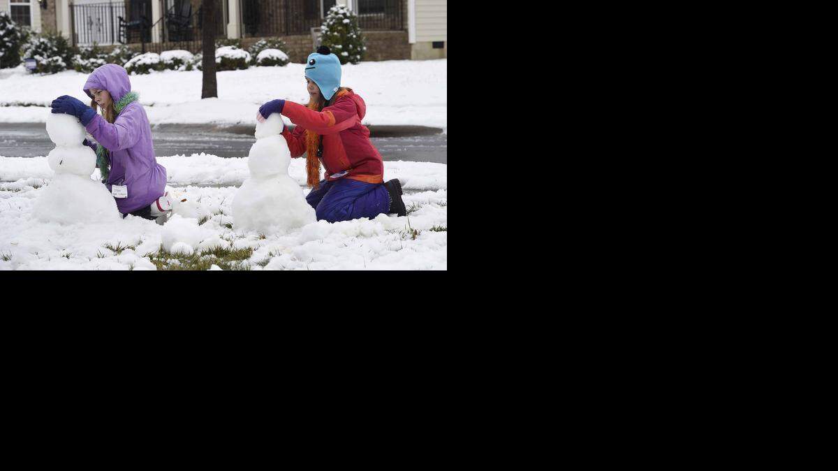 
Sisters  Olivia Reed 10 and Nora Reed 7, make snow men in the front yard of their home in Gastonia. Gaston County Schools were closed Thursday.
