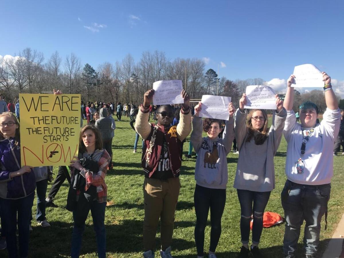 Students at Charlotte-Mecklenburg’s Randolph Middle School display signs during their walkout. An estimated 400 students took part.