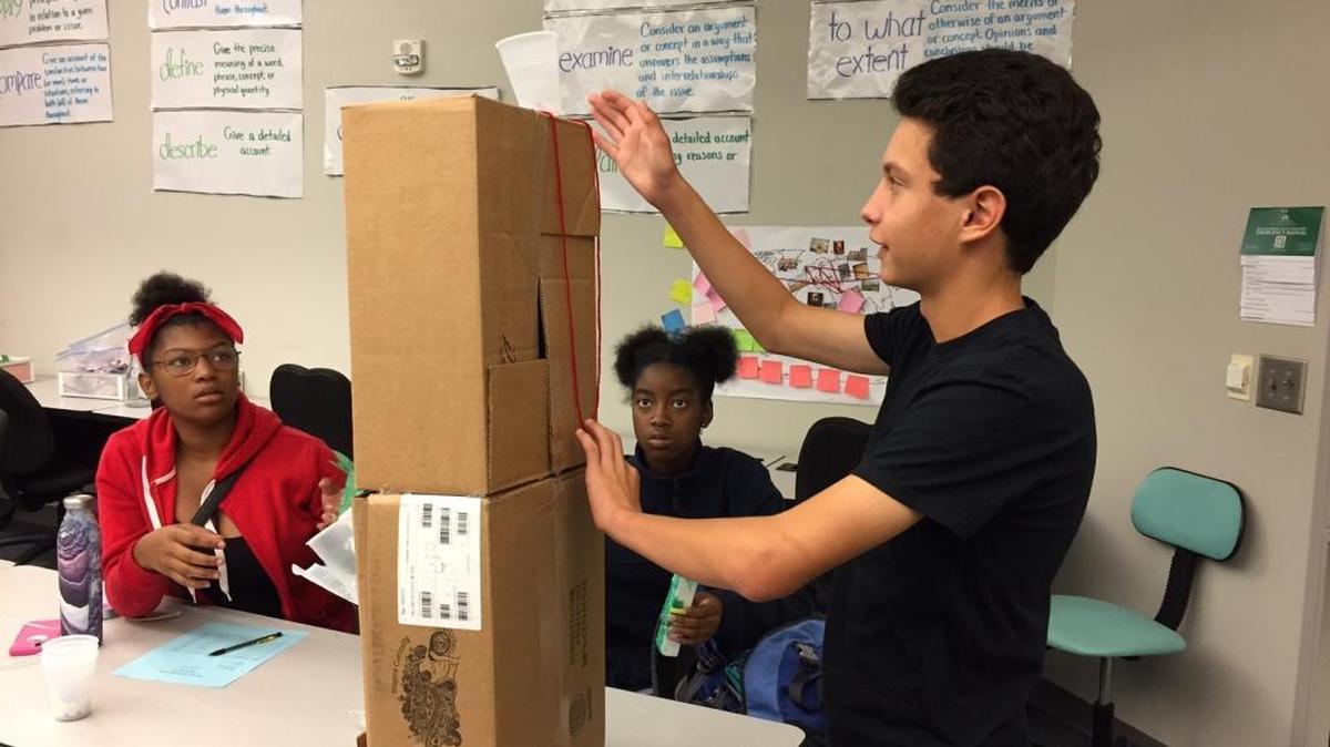 Neal Kapur, one of the first ninth-graders at Charlotte Teacher Early College high school on the UNC Charlotte campus, explains his contribution to a machine demonstrating evaporation and precipitation.