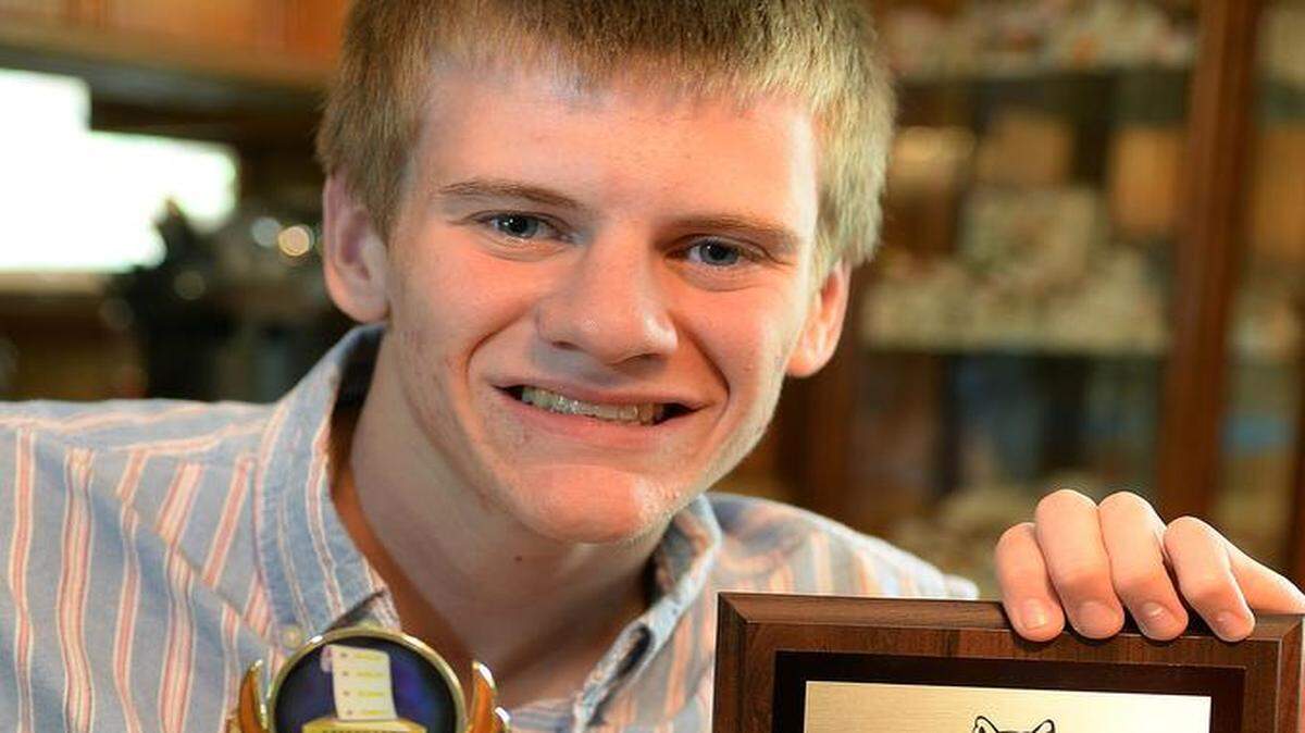 
Justice Fleming, a graduating senior who has achieved perfect attendance through 12 years in CMS, displays awards for his diligence.
