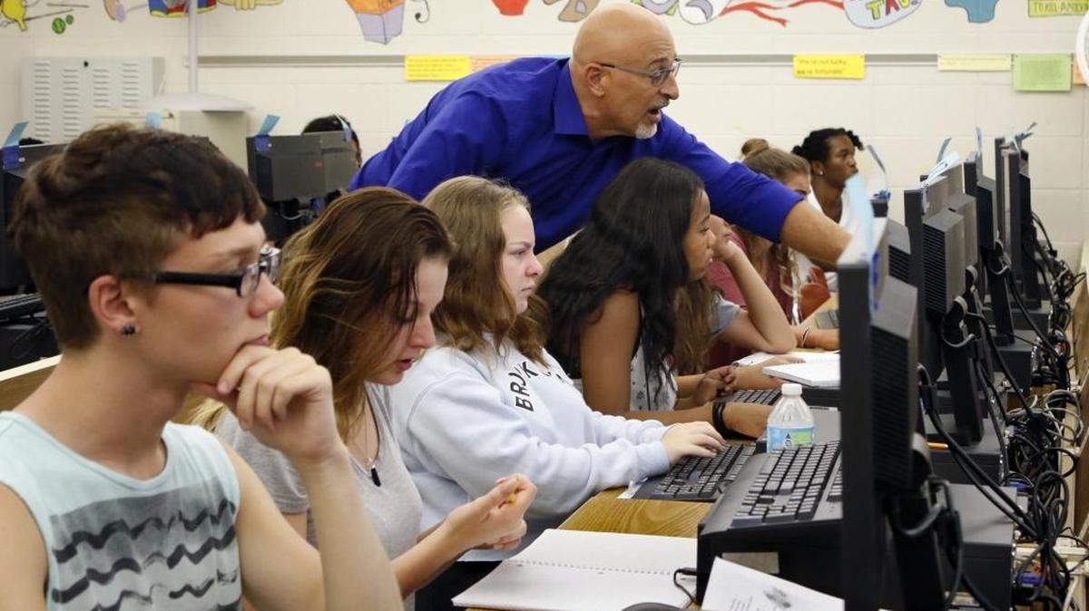 Credit recovery class instructor Mike Bellissimo helps students focus their online studies during their computer lab at Sanderson High School in Raleigh.