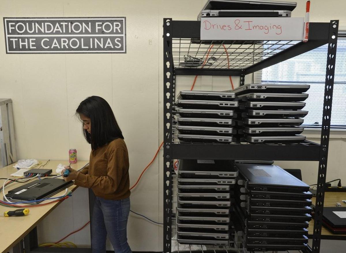 Meredith Toca, 17, prepares to install a hard drive into a laptop computer in the E2D lab on campus at Garinger High.