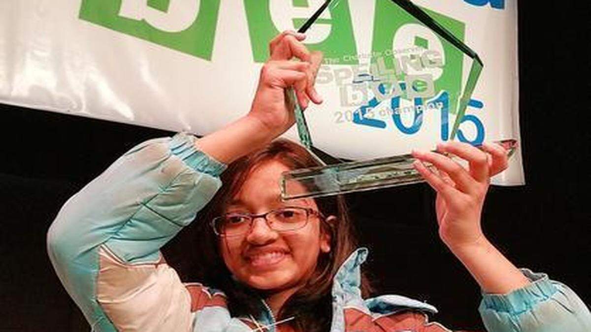 
Akshra Paimagam, 12, a Randolph Middle sixth-grader, hoists her trophy Monday after winning the 2015 Charlotte Observer Spelling Bee. She will compete in the 90th Scripps National Spelling Bee in May. Paimagam also won a Webster’s Third New International Dictionary and the Samuel Louis Sugarman award certificate for a 2015 United States Mint Proof Set.
