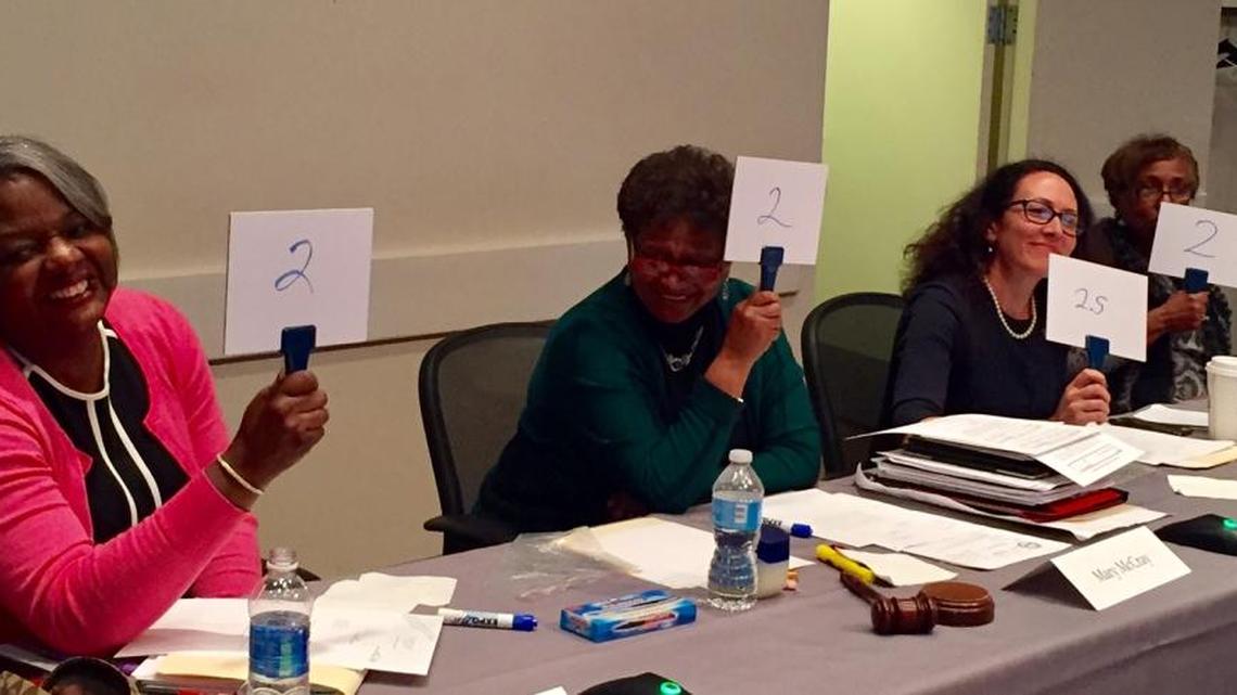 Charlotte-Mecklenburg school board members (left-right) Ericka Ellis-Stewart, Mary McCray, Elyse Dashew and Ruby Jones hold up rating cards during a Tuesday discussion of educational equity.