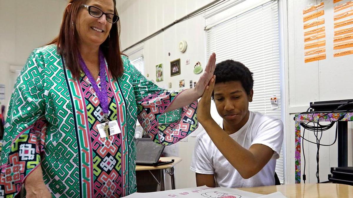 Lowe’s Grove Middle School teacher Jenny Duvall works with eighth-grader Julius Borunda as part of a Durham program to provide more challenging classes to low-income students with high potential.