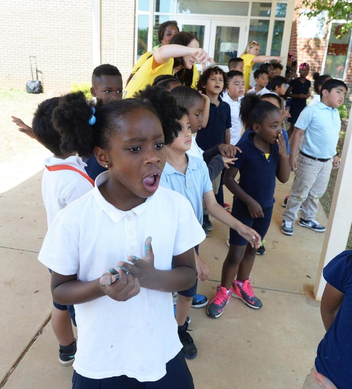 Idlewild student Alexia Harris, 7, react to seeing her school’s new garden, built by Target employees, school families and the nonprofit Real School Gardens.