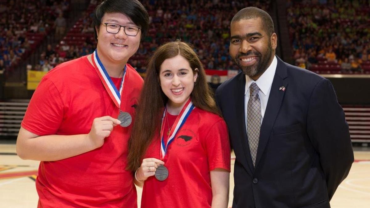 Joseph Chong, left, celebrates winning second place in documentaries with his partner Catherine McMillan, middle, and Julian Hipkins, right, a member of the National History Day Board of Trustees.