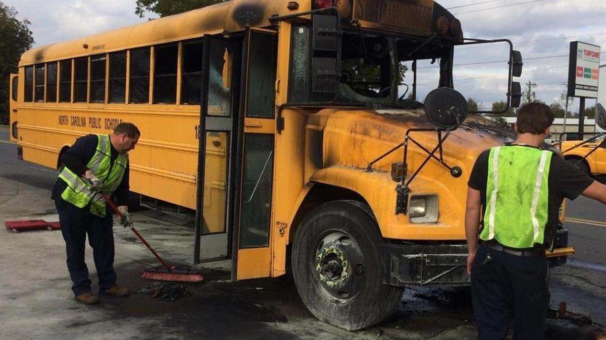 Workers clean up after a CMS bus caught fire in November.