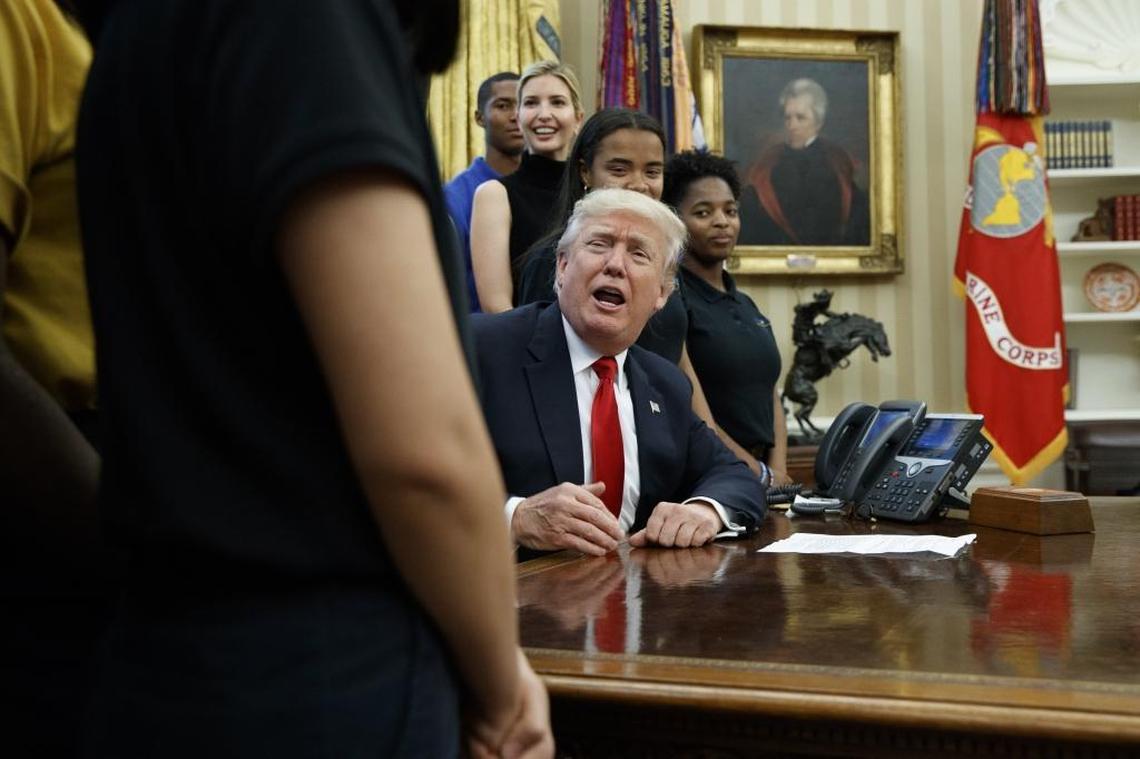 President Donald Trump speaks to reporters during a visit by the Victory Christian Center School as his daughter, Ivanka Trump, looks on.