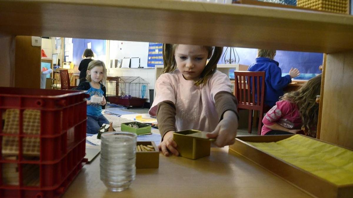 2015 file – Sienna Moulton opens a container before beginning a project in the four and five year old class at Park Road Montessori, a CMS magnet school.