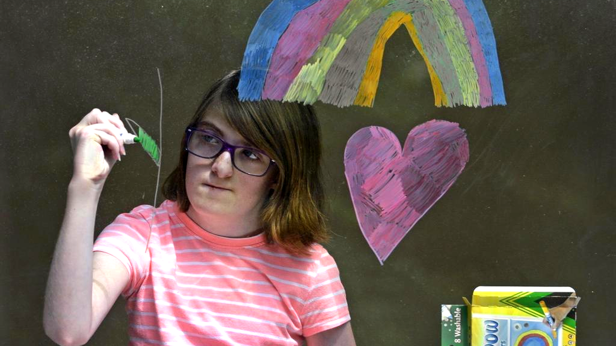 Ninth-grader Peyton Brockman paints the inside of a window at the new Montessori high school, a Charlotte-Mecklenburg Schools magnet that’s temporarily housed at Sedgefield Middle.