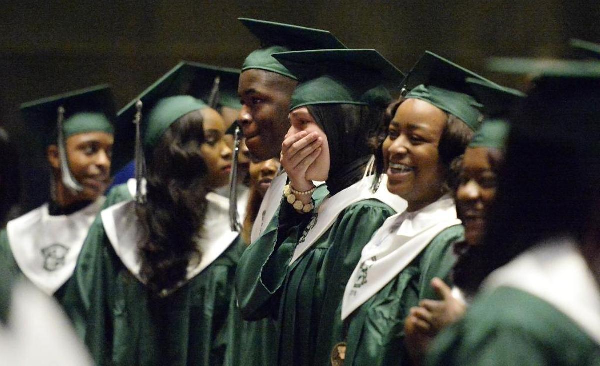 Sondous Khaleel Eksheir, center, reacts with her classmates at commencement for Cato Middle College High Thursday .