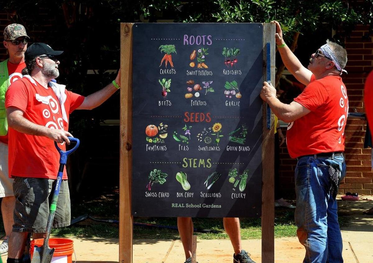 Volunteers erect signs at Idlewild Elementary’s new outdoor garden classroom.