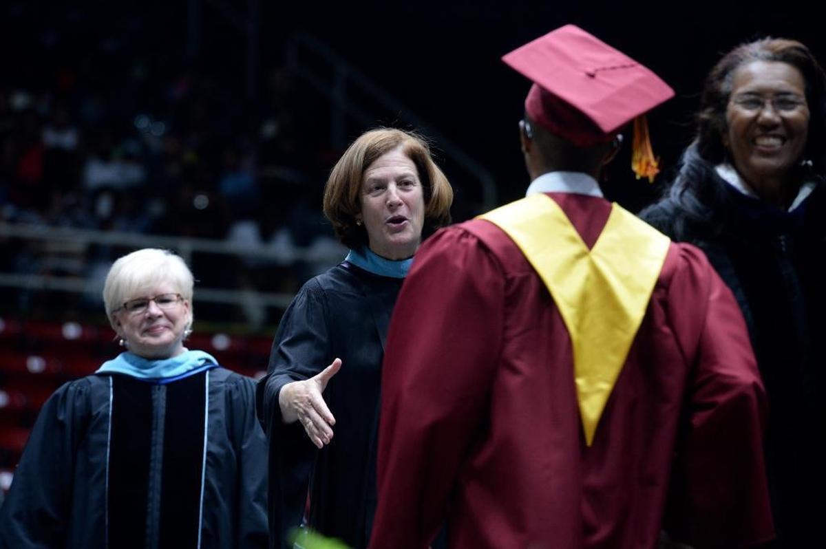 Superintendent Ann Clark, wrapping up her 34 year career with CMS, shakes hands with graduating students during the Harding High graduation at Bojangles’ Coliseum.