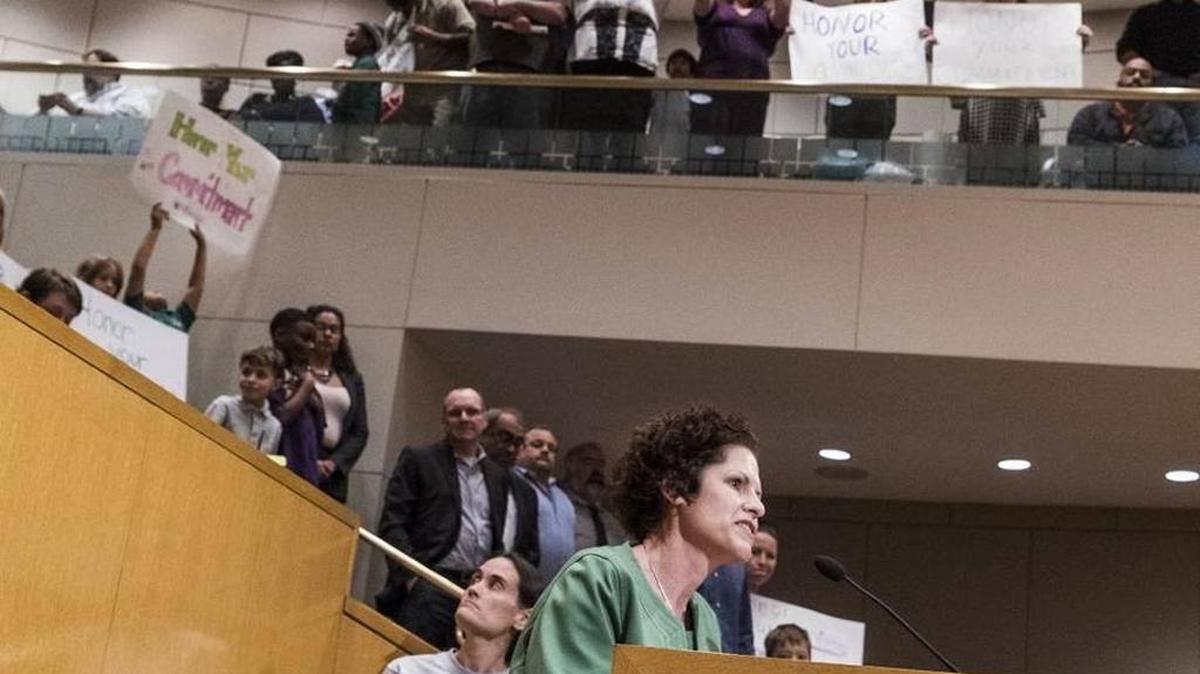Veritas supporters held signs asking the Charlotte Mecklenburg school board to "Honor your Commitment" as founder Katy Ridnouer tried Nov. 10 to fight lease termination.