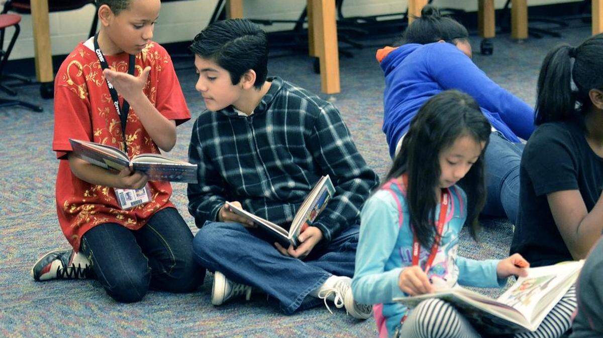 (L-R) Zechariah Wood and Daniel Diaz, fifth-graders at Stoney Creek Elementary, talk about a book in the media center on Friday, Dec. 18, 2015.