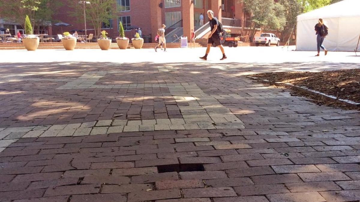 N.C. State University students have a tradition of taking bricks as souvenirs, a missing one seen here, (foreground) , on the Brickyard on the school campus in Raleigh, NC on April 21, 2017. N.C. State University is giving bricks away to students, to dissuade them from stealing them from campus walkways.