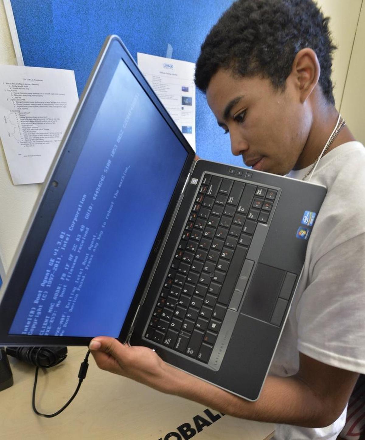 Cameron Twiggs, a sophomore at Garinger High, works on refurbishing a laptop at the E2D lab on the Garinger High campus.