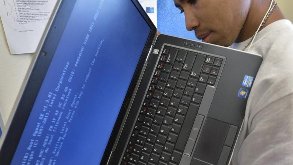 Cameron Twiggs, a sophomore at Garinger High, works on refurbishing a laptop at the E2D lab on the Garinger High campus.