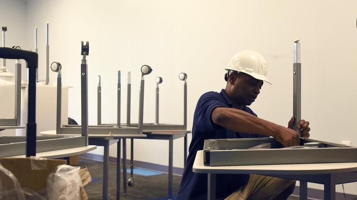 Craig Robinson, a furniture installer, sets up a first grade classroom at Mallard Creek STEM Academy on Thursday, four days before the new charter school opens.