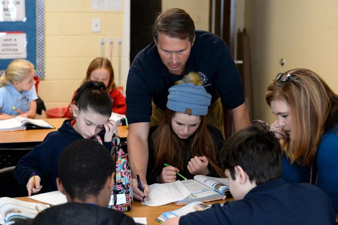 Mountain Island Day School co-founder Tom Winstead (center) and middle school teacher Kris Poole help students with math problems. The Winsteads say their school already has a strong foundation in secular academics and a faculty of licensed teachers.