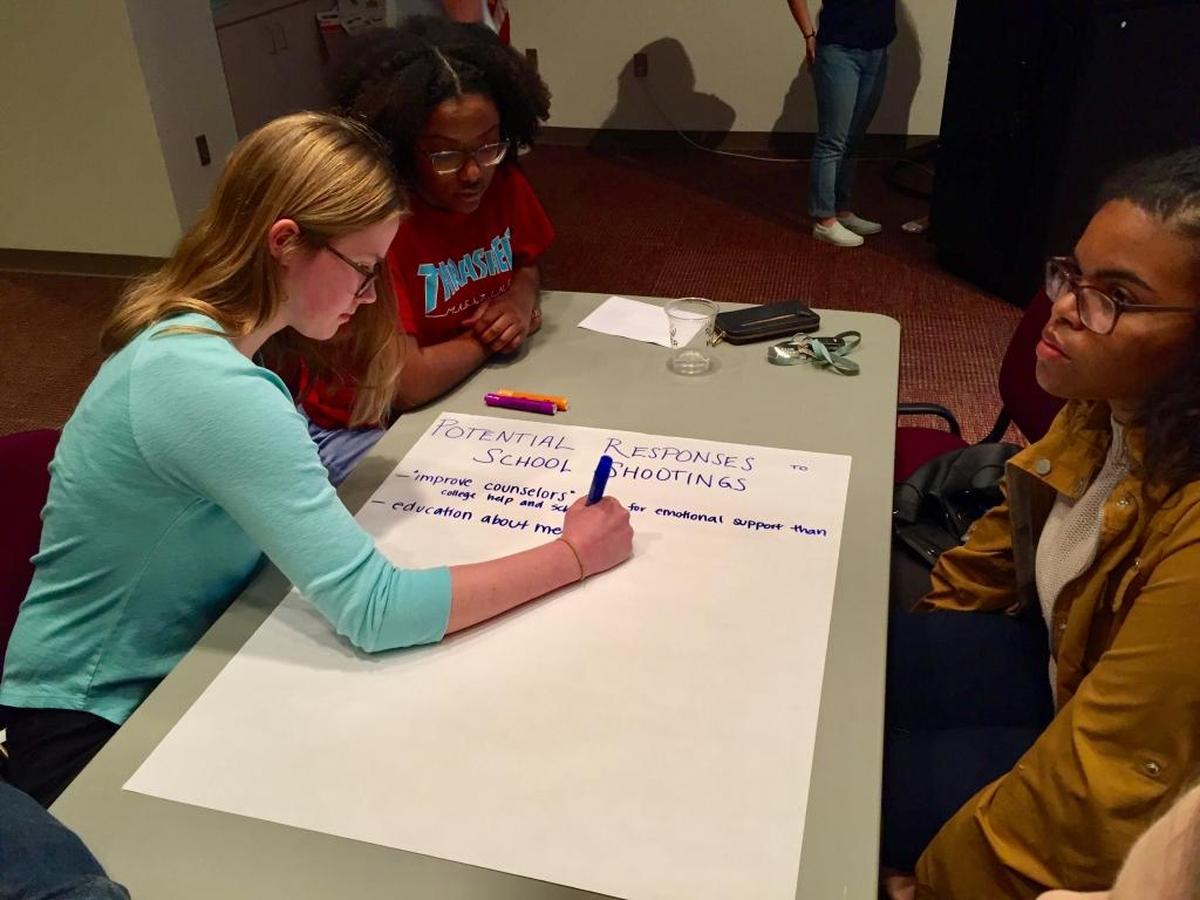 Myers Park High student Emma-Katherine Bowers writes student suggestions during a February 2018 Mecklenburg Youth Council meeting on school safety .