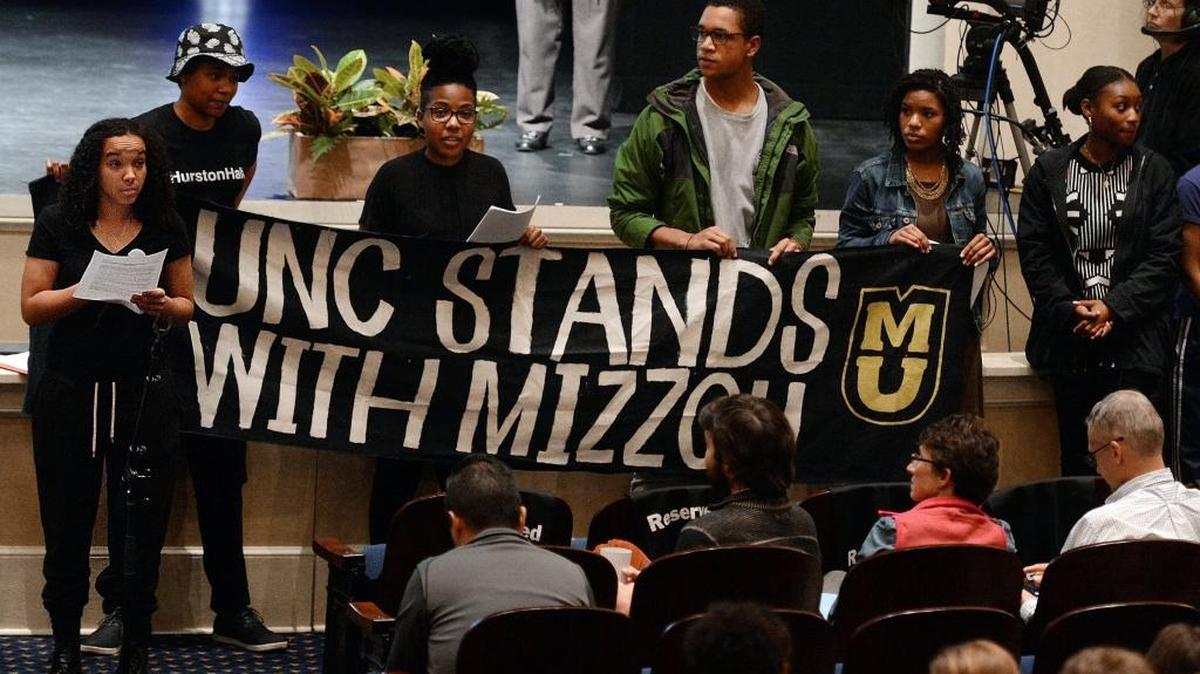 UNC senior June Beshea reads a list of demands to a full house at Memorial Hall on the campus of UNC in Chapel Hill, N.C. Thursday, Nov. 19, 2015. A group of about 50 protesters left their seats and took control of the microphone to address the audience with a list of demands during a Town Hall meeting.