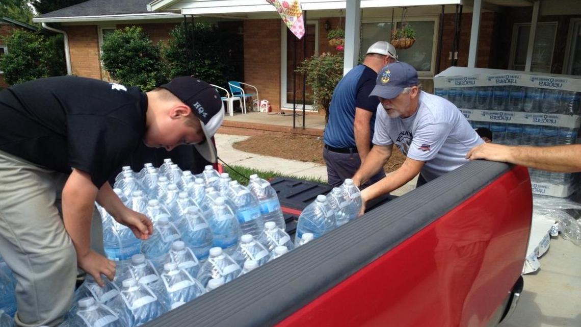 Neighbors with tainted wells in Belmont stack bottled water.