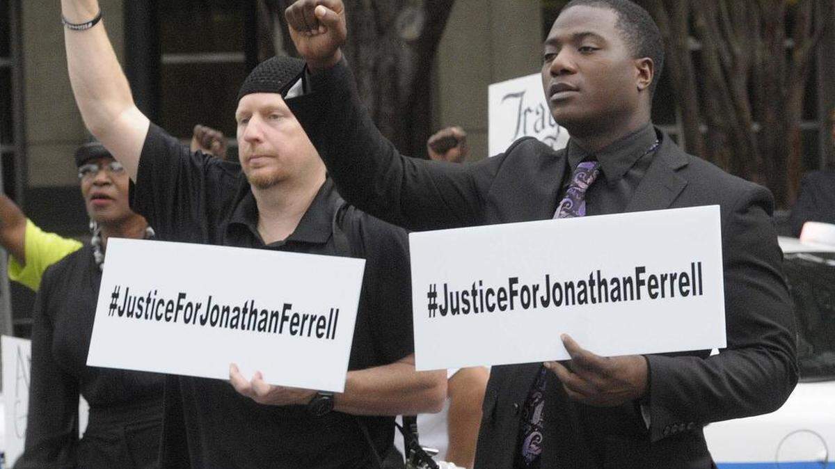 
 From left, holding up their fists Jibril Hough, a Muslim leader Willie Ferrell, brother of Jonathan Ferrell, during the Charlotte 'die-in' in honor of Jonathan Ferrell held in the street in front of the Mecklenburg County Jail and Mecklenburg County Courthouse on Monday August 10,2015. Die-ins involve lying in public spaces to illustrate what many see as a national wave of police brutality against African-Americans.
