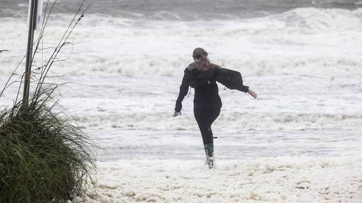 A girl battles wind as she walks on the beach early Saturday morning in Cherry Grove as Hurricane Matthew made its way to the area.