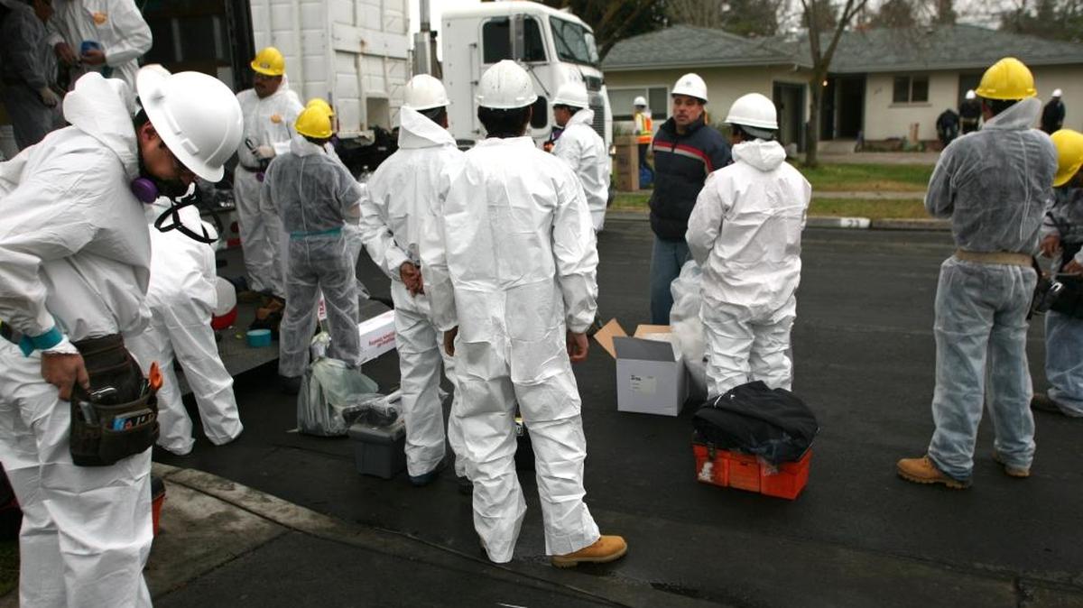 Workers controlling asbestos in Davidson will wear protective gear like that worn by these men at a home renovation site in California.