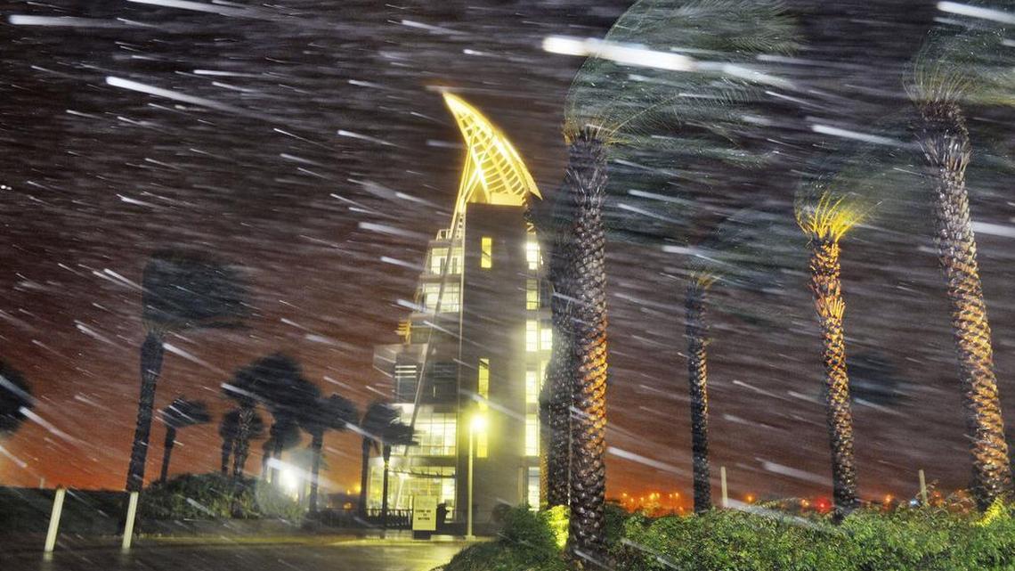 Trees sway from heavy rain and wind from Hurricane Matthew in front of Exploration Tower early Friday, Oct. 7, 2016 in Cape Canaveral, Fla. Matthew weakened slightly to a Category 3 storm with maximum sustained winds near 120 mph, but the U.S. National Hurricane Center says it's expected to remain a powerful hurricane as it moves closer to the coast. (Craig Rubadoux/Florida Today via AP)
