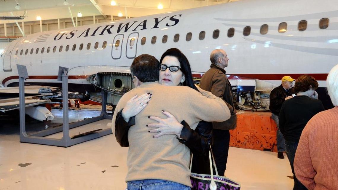 In this 2012 photo, Flight 1549 passenger Stephen Lis of Phildelphia, on left, hugs Denise Lockie of Charlotte, on right, before looking inside the plane. On the third anniversary of their “Miracle on the Hudson” crash, passengers of Flight 1549 gathered at the Carolinas Aviation Museum and sat in their old seats in the fuselage of the jetliner.